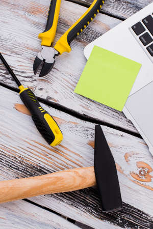 Repair working tools and blank sticker for copy space. White wooden table on the background. Top view flat lay.の写真素材