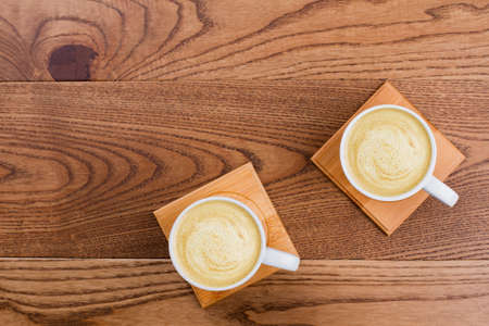 Two cups of coffee cappuccino on wood. Topview flat lay.