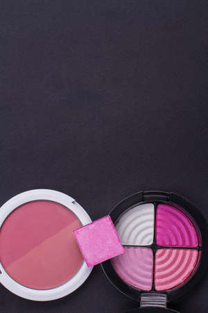 Pink blush for face from top on black background. Copy space in upper part.