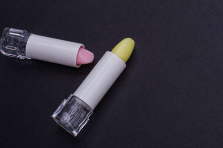 Two pink and light yellow lipsticks in an open case. Flat lay cosmetics from top view.の写真素材