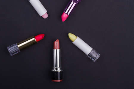 Set of bright multicolored lipsticks on black background. Red pink yellow lipsticks.の写真素材