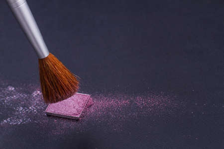 Close-up blusher and brown brush on dark background. Concept of women cosmetics.の写真素材