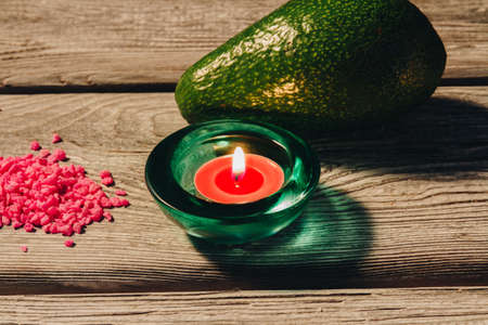 Natural avocado healthy for skin, burning candle and pink sea salts. Wellness and skincare concept.の写真素材