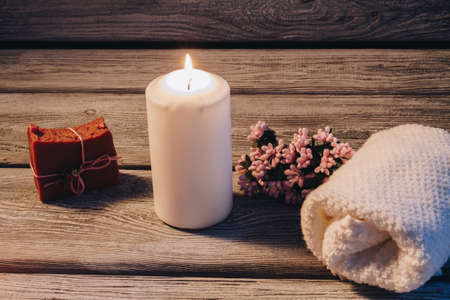 Spa concept with burning big candle and spa accessories on wooden floor Beautiful composition with...