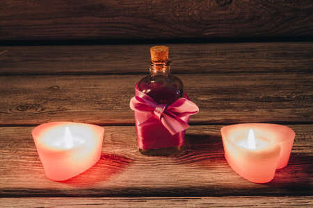 Aroma oil bottle with burning candles on wood. Spa relaxation concept.の写真素材