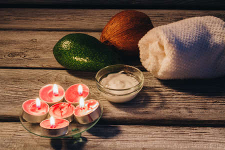 Aroma spa stuff concept. Avocado with cocnut and towel on a wooden background.