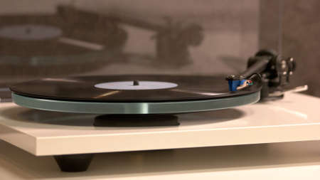 Old record is playing by the gramophone. Vintage old record.の写真素材