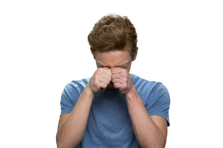 Portrait of crying teen boy. Sorrow and stress. Isolated on white background.の写真素材