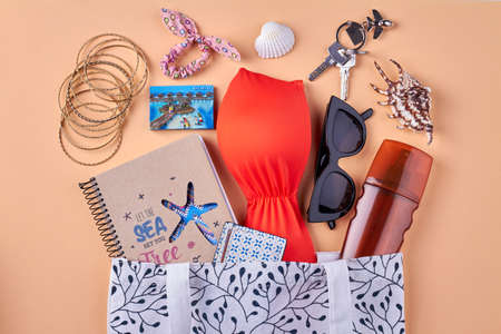 Flat lay beach resort female accessories. Isolated on beige background.の写真素材