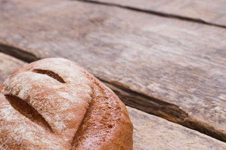 Freshly baked homemade bread. Loaf of natural bread on rustic wooden boards. Space for text.の写真素材