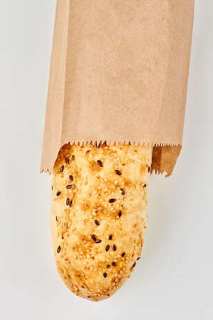 French baguette in kraft paper, top view. Crispy french bread isolated on white background.
