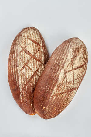 Bread on white background, top view. Two loaves of sourdough bread. Traditional homemade food.