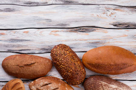 Wholemeal wheat bread loaves and copy space. Homemade bread loaves on vintage wooden background.