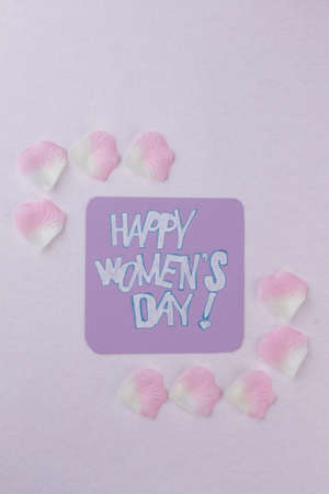 Happy womens day wish with flowers petals. Top view flat lay.