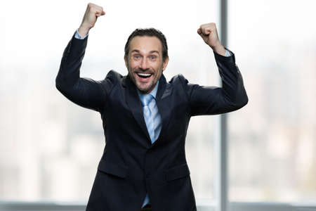 Excited businessman celebrating success. Ecstatic caucasian enterpreneur excited about success. Victory and business achievement concept.の写真素材