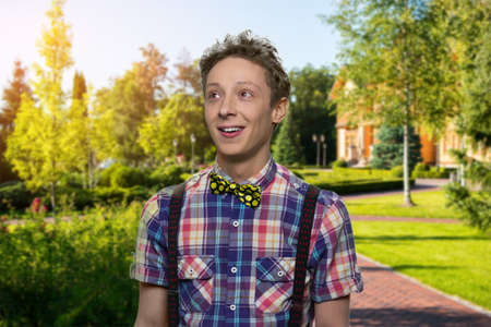 Portrait of cute day dreaming teen boy. Smiling teenage boy with pensive expression on nature...
