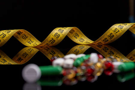 Weight loss using dope concept. Measure tape and various medicine close-up.の写真素材