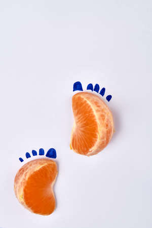 Two mandaring slices as footsteps. Isolated on white background.の写真素材