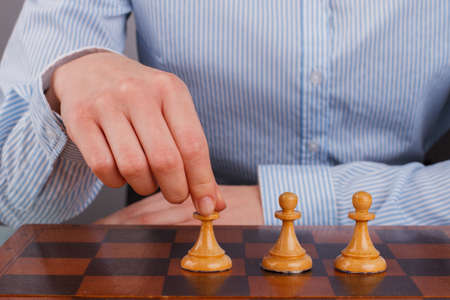 Hand of business woman playing chess game. Business strategy for victory.