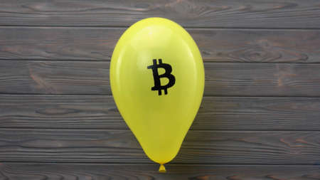Yellow balloon with bitcoin sign. Concept of cryptocurrency as an unreliable financial pyramid....