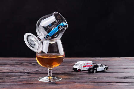 Composition of glasses for alcohol and toy cars. Drunk drive and car accident concept.