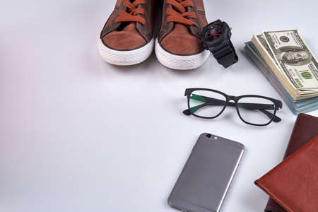 Arrangement of mens accessories. Smartphone with glasses, shoes and money. Isolated on white background.の写真素材