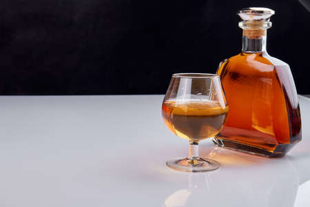 Bottle and glass of whiskey. Bottle with no lables. Black and white background.の写真素材