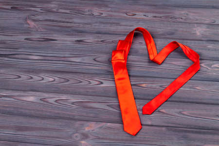 Heart-shaped red tie on wood. Top view love concept.の写真素材