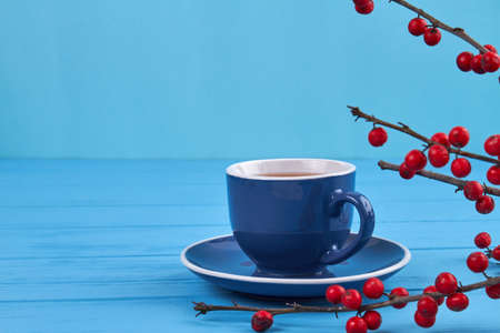 Cup of tea and rowanberry. Blue wooden table.の写真素材