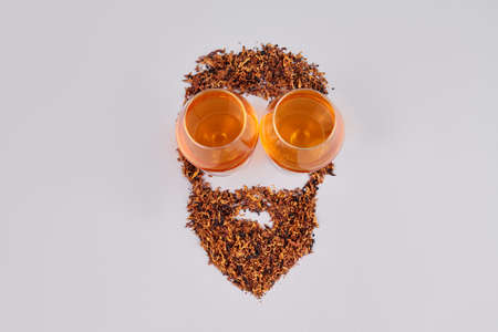 Mens face made of tea. Eyes of tea glasses. Isolated on white background.