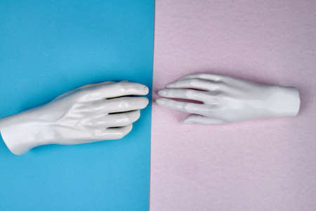 Touching of mannequin hands. Turquoise and white background.の写真素材