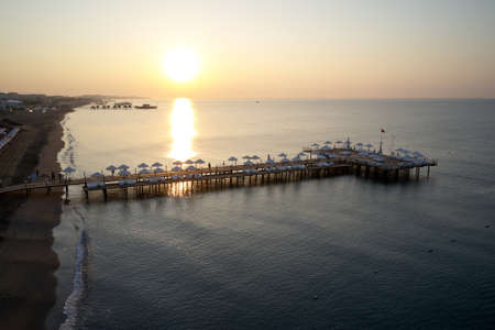 Breathtaking sunset over the sea. Top view of wooden pier bridge against beautiful sunset sky. Seashore vacation concept.の写真素材