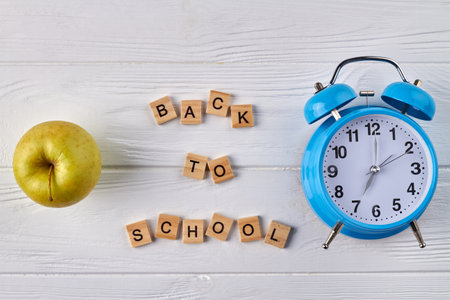 Alarm clock and green apple. Back to school concept.の写真素材