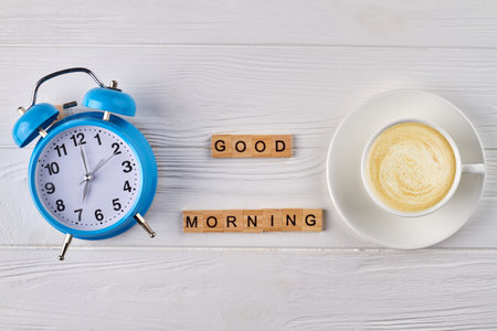 Top view alarm clock and empty coffee cup. Good morning made of woodem cubes.の写真素材