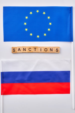Flags of Russian and European Union. Word sanctions made of wooden cubes.の写真素材