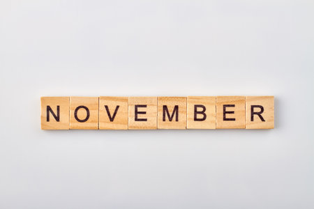 November word written on wooden blocks. Isolated on white background.の写真素材