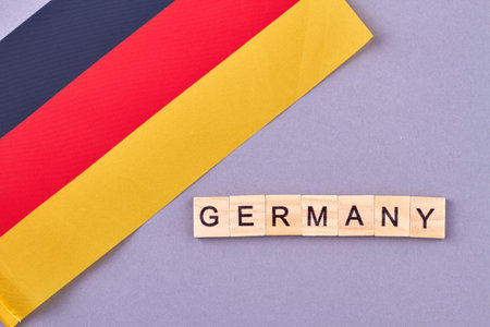 Germany flag on purple background. Country concept written with wooden blocks.の写真素材