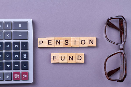 Words pension fund with calculator and glasses on desk. Investment of retirement concept. Calculator...