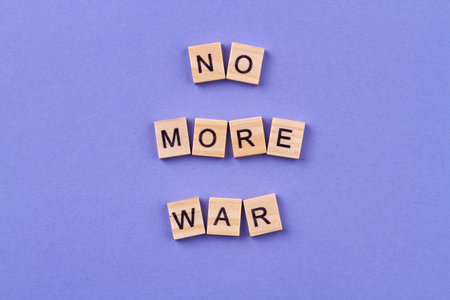 Stop the war concept. Idea of humanity and peace. Wooden cubes with letters isolated on blue background.の写真素材