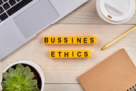 Bussines ethics concept. Tools for work and cup of coffee near the laptop on the desk. Yellow blocks on the wooden desk.の写真素材