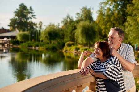 Smiling mature couple enjoying landscape. Happy caucasian man and woman. Pond and trees background.の写真素材