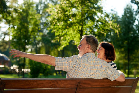 Retired man pointing at something. Take a look. Mature husband and his wife outdoors.の写真素材