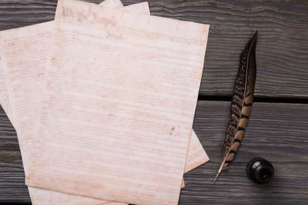 Old paper with quill and ink. Top view flat lay, Feather for writing.の写真素材