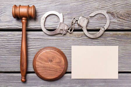Flat lay justuce and court concept. Blank paper for copy space. Wooden gavel with handcuffs on the desk.の写真素材