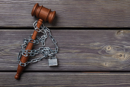 Court restrictions concept. Wooden gavel with padlock and chains.の写真素材