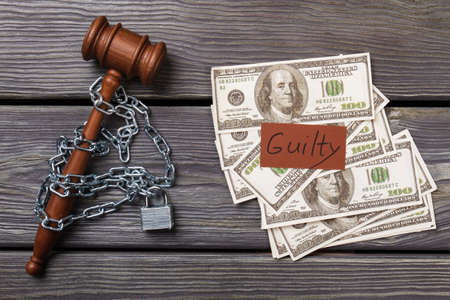 Flat lay guilty verdict in a court concept. wooden gavel chained with padlock.の写真素材
