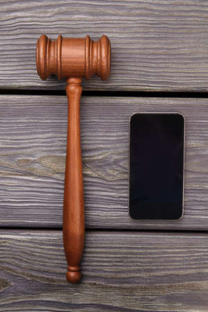 Gavel and smartphone on a grey desk. Top view flat lay vertical shot.の写真素材
