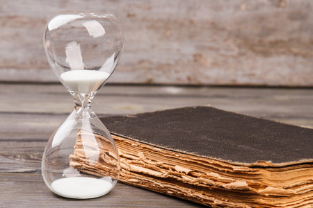 Hourglasse and book. Time and knowledge concept.