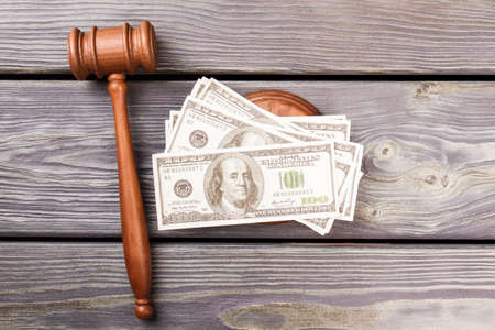 Judge hammer and money. Wooden gavel and dollars on wood top view.の写真素材
