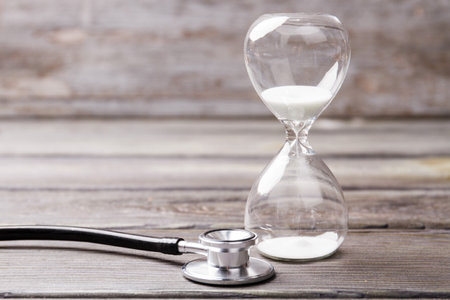 White hourglass and stethoscope. Lifetime and aging concept.の写真素材